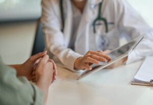 doctor showing a patient information on a digital tablet