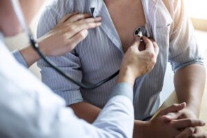 Doctor using a stethoscope checking patient